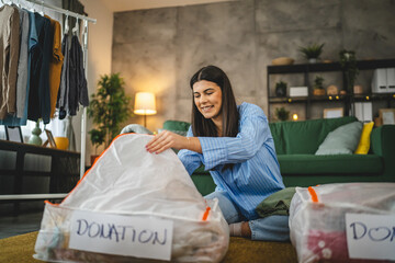 One woman caucasian adult at home choose clothes for charity donation