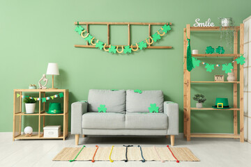 Interior of festive living room with grey sofa and decorations for St. Patrick's Day celebration - obrazy, fototapety, plakaty