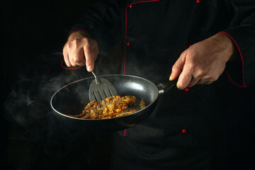 Fish chef frying crucian fish in a frying pan. The concept of preparing a fish dish for breakfast. Black space for advertising