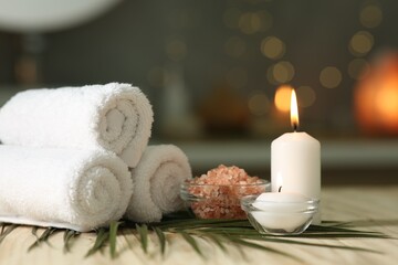 Composition with different spa products and burning candles on wooden table indoors