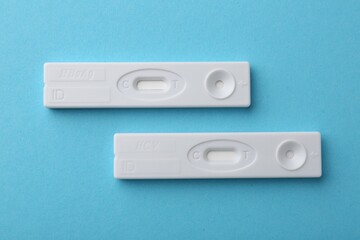 Disposable express tests on light blue background, top view