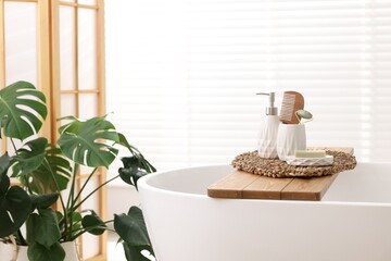 Different personal care products and accessories on bath tub in bathroom