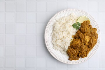 Delicious chicken curry with rice on white tiled table, top view. Space for text