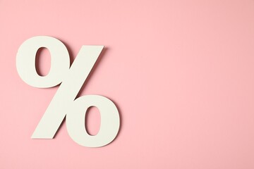 White percent sign on pink background, top view. Space for text