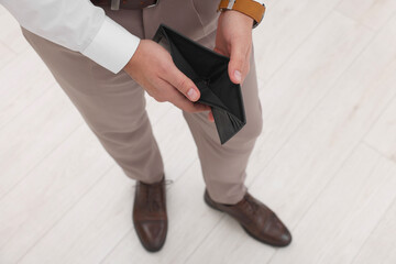 Man with empty wallet indoors, above view