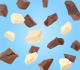 White and milk chocolate chunks on light blue background