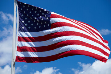 American Flag Waving in the Wind with Blue Sky, Clouds