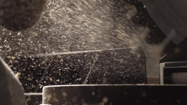 slow motion video of a circular saw in 4K resolution and wood chips and sawdust flying. 