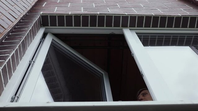 Adult man says something and closes window. Slow motion
