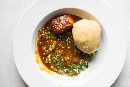 Nigerian okro and stew with eba in a white plate, top view of okro soup and eba