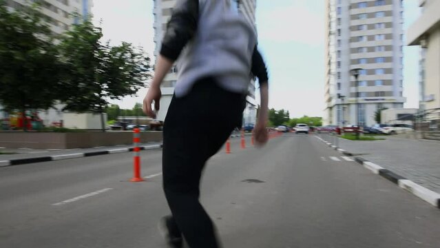 Young man does somersault on street during extreme parkour training. Slow motion