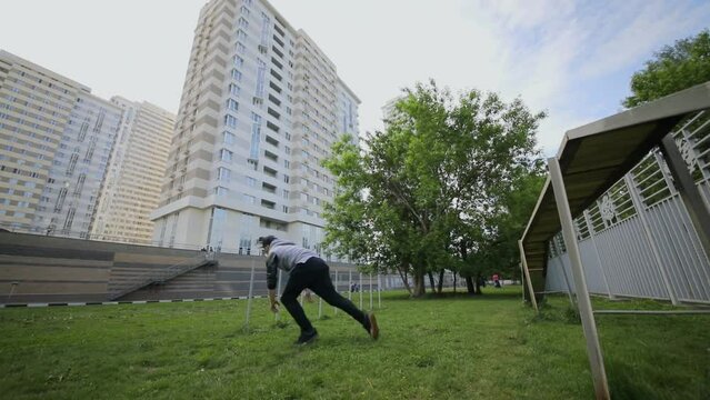 Young man does back flip from platform on street. Slow motion