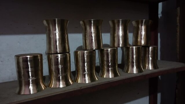 Copper-brass household water glasses on display.