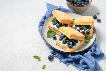 Stuffed puff cookies with whipped cream and blueberries