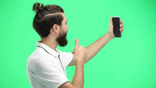 Man, close-up, on a green background, with a phone