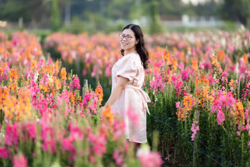 Fototapeta na wymiar Portrait of asian Young woman happy traveler with white dress enjoying in white blooming or purple Michaelmas Daisy flower field in the nature garden of in Chiang Mai,Thailand,travel relax vacation