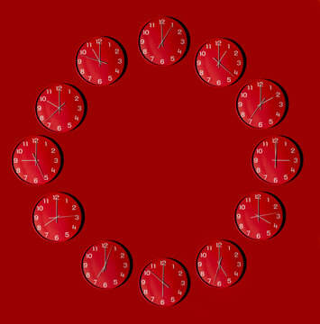 Circular formation of wall clocks on red background