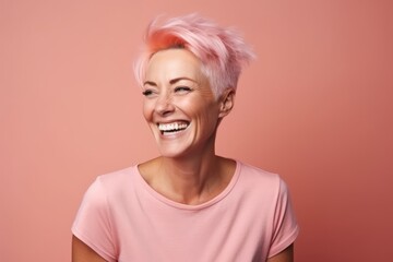 Happy woman with pink hair smiling at the camera on a pink background