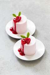 Valentine's Day dessert. Raspberry cream pudding. Panna Cotta. With raspberry sauce. On a plate. Light gray background. Top view