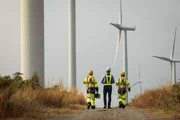 Maintenance engineers working on wind farm, team of wind turbine experts discussing clean energy production. alternative renewable energy concept - obrazy, fototapety, plakaty