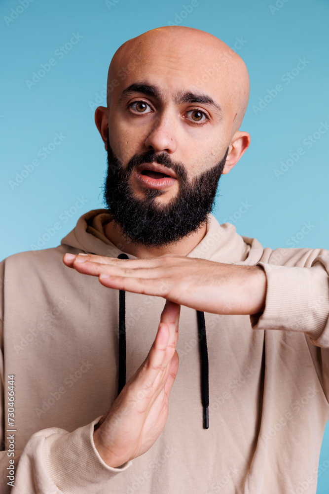 Poster arabian person taking time out with stop signal while showing confident facial expression portrait. 