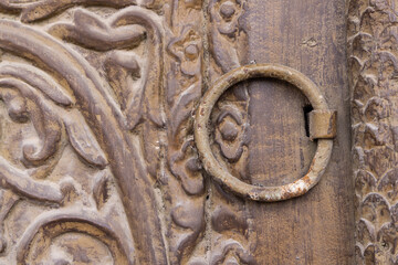 Metal pull on a carved wooden door in the Al-Balad historical district.