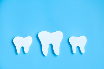 Paper cut mockup of tooth on blue background. Dental care concept. International Dentist Day.