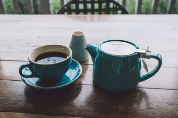 cup of tea and tea pot on table