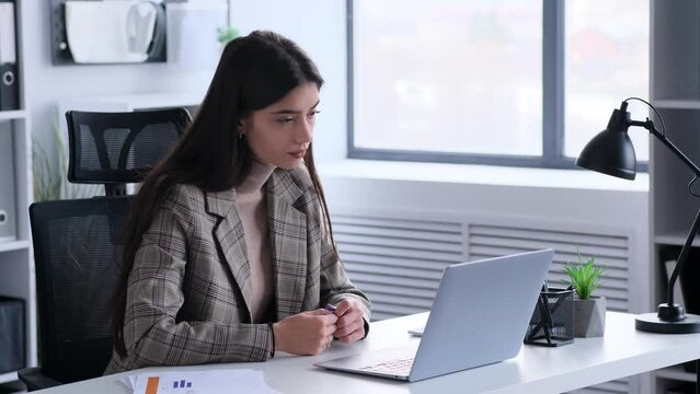 Caucasian nervous Woman office worker waiting for answer, exam results or deal while working with laptop in modern office. Concentrated and focused businesswoman.