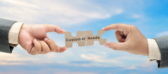 Two business hand holding pieces of a jigsaw puzzle with customer needs text