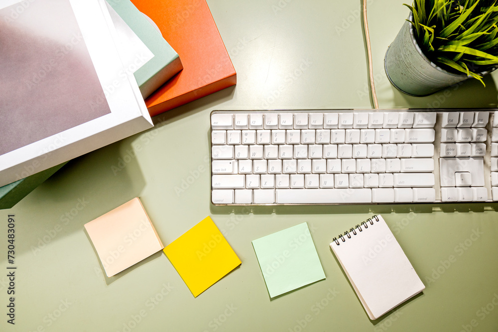 Poster closeup view of computer keyboard and an empty notebook and note paper