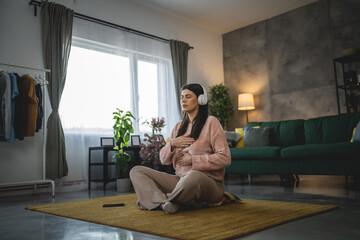 Obraz premium one woman doing guided meditation yoga self care practice at home