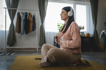 one woman doing guided meditation yoga self care practice at home