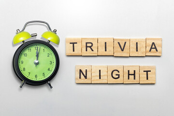 Alarm clock and a row of wooden cubes with trivia night text
