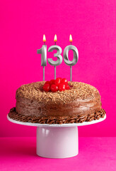 Birthday card with candle number 130 - Chocolate cake on pink background