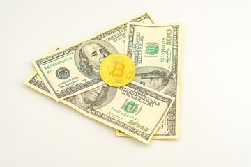 Gold Bitcoin on hundred dollars bills. Golden symbolic coin Bitcoin on banknotes of one hundred dollars. Cryptocurrency on US dollar bills. Digital modern method of payment. Exchange bitcoin cash