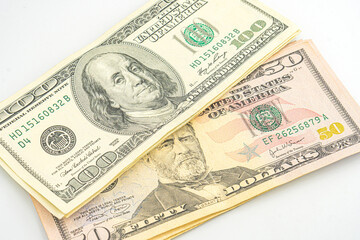 Close up of different dollar bills. Isolated on a white background. 100 and 50 dollar bundles up close on a white background
