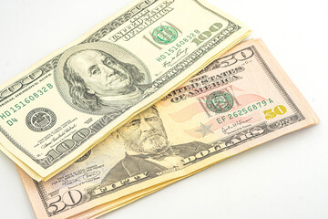 Close up of different dollar bills. Isolated on a white background. 100 and 50 dollar bundles up close on a white background