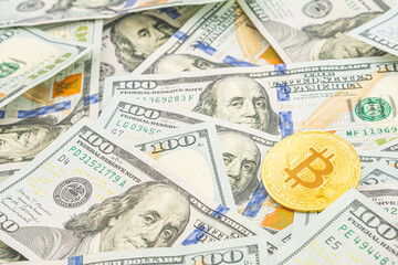 Gold Bitcoin on hundred dollars bills. Golden symbolic coin Bitcoin on banknotes of one hundred dollars. Cryptocurrency on US dollar bills. Digital modern method of payment. Exchange bitcoin cash