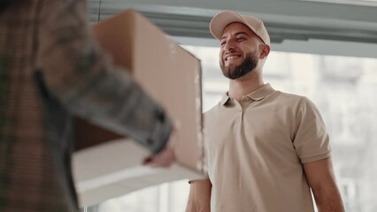 A cheerful courier in casual attire delivers a large box, showcasing convenience and reliability in parcel delivery service.