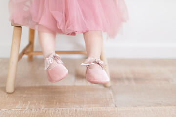 Close up of baby feet with pink ballet slippers and a pink tutu