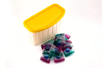 concentrated detergent in water-soluble capsule and plastic storage container