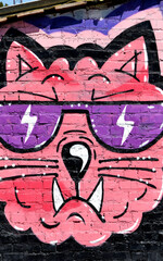 Colorful background of graffiti painting artwork with bright aerosol outlines on wall. Old school street art piece made with aerosol spray paint cans. Contemporary youth culture backdrop
