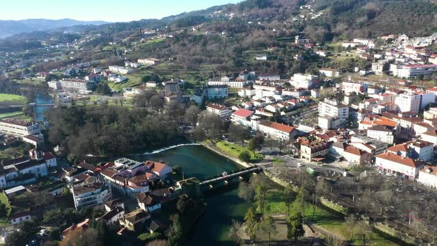 Drone orbit above River Vez bridge or Ponte da Vila and town of Arcos de Valdevez in Portugal, aerial pan establish