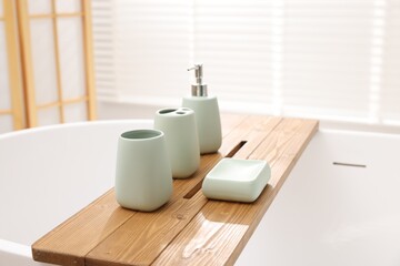 Set of bath accessories on tub in bathroom