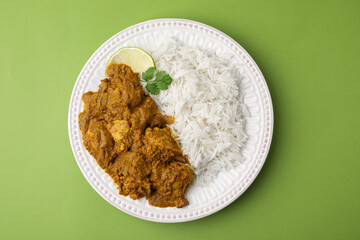 Delicious chicken curry with rice on green background, top view