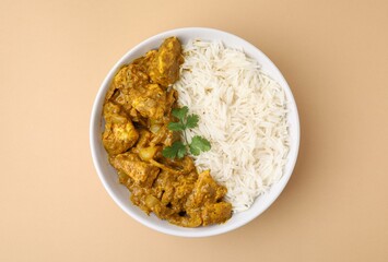 Delicious chicken curry with rice on beige background, top view