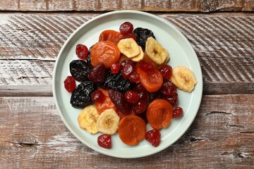 Mix of delicious dried fruits on wooden table, top view