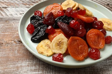 Mix of delicious dried fruits on wooden table, closeup