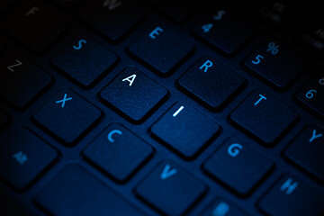 keyboard being illuminated with blue light highlighting letters a i
